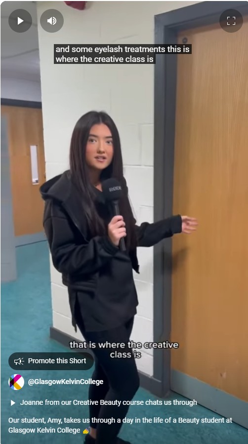 A beauty student holding a microphone and introducing the creative beauty class at Glasgow Kelvin College.
