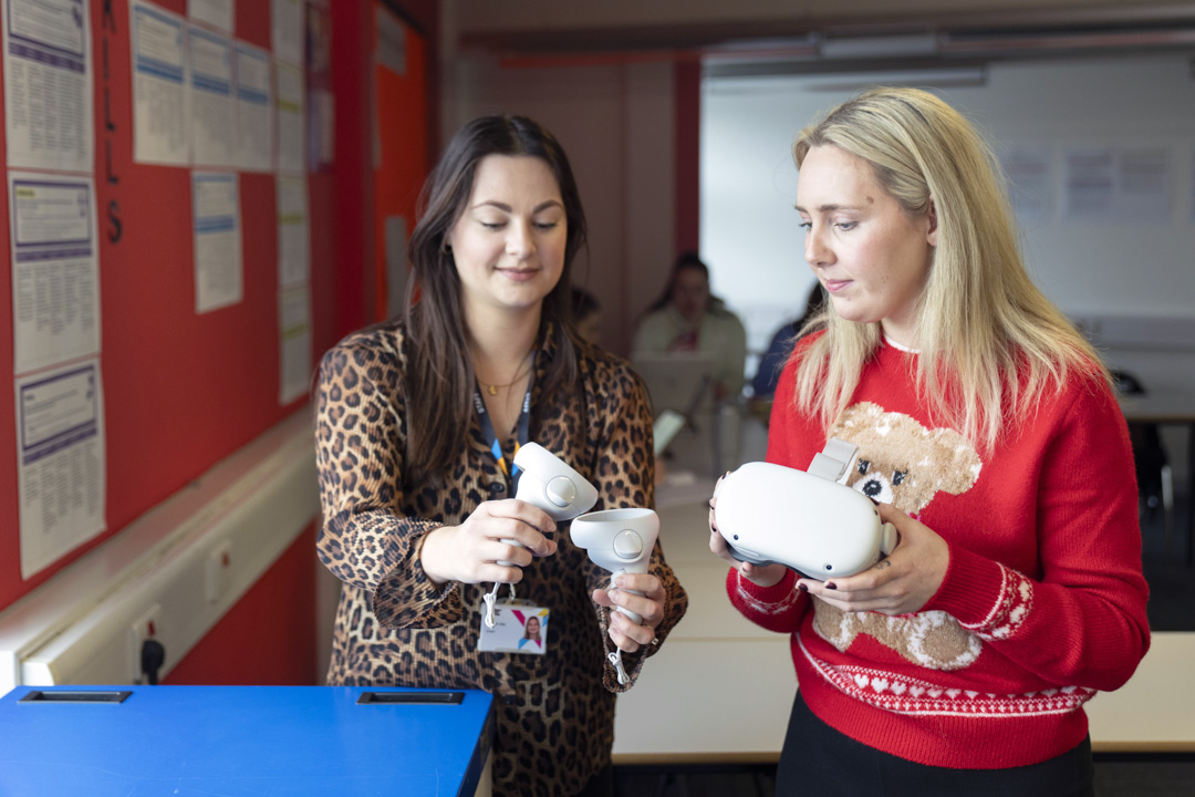 Lecturer and student examining virtual reality equipment during a lesson at Glasgow Kelvin College.