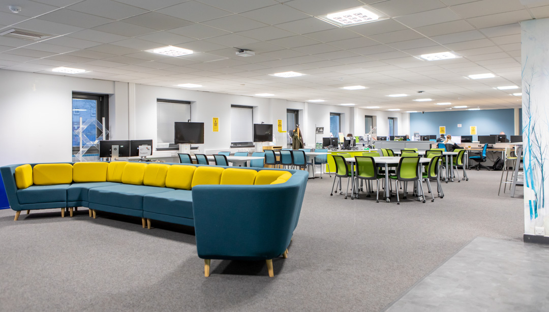 Bright and modern library and flexible learning centre at Glasgow Kelvin College Easterhouse Campus, featuring computers, group tables, and colourful seating.