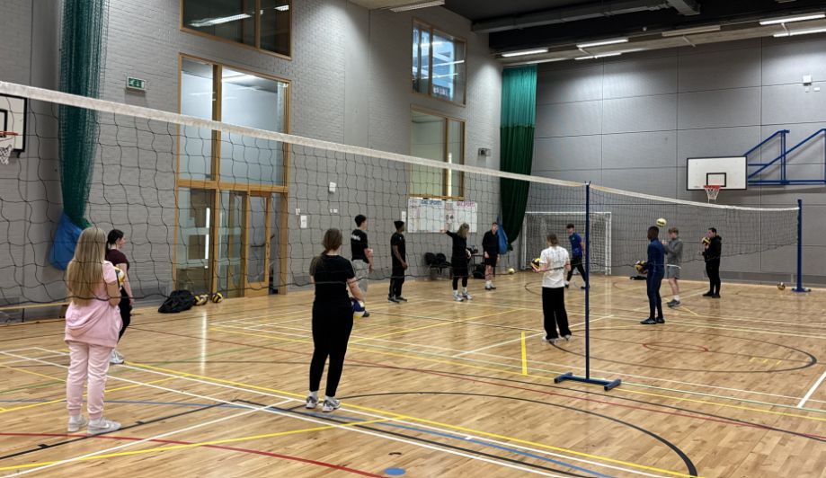 Students taking part in a volleyball training session in the college sports hall during a Scottish Volleyball CPD event.