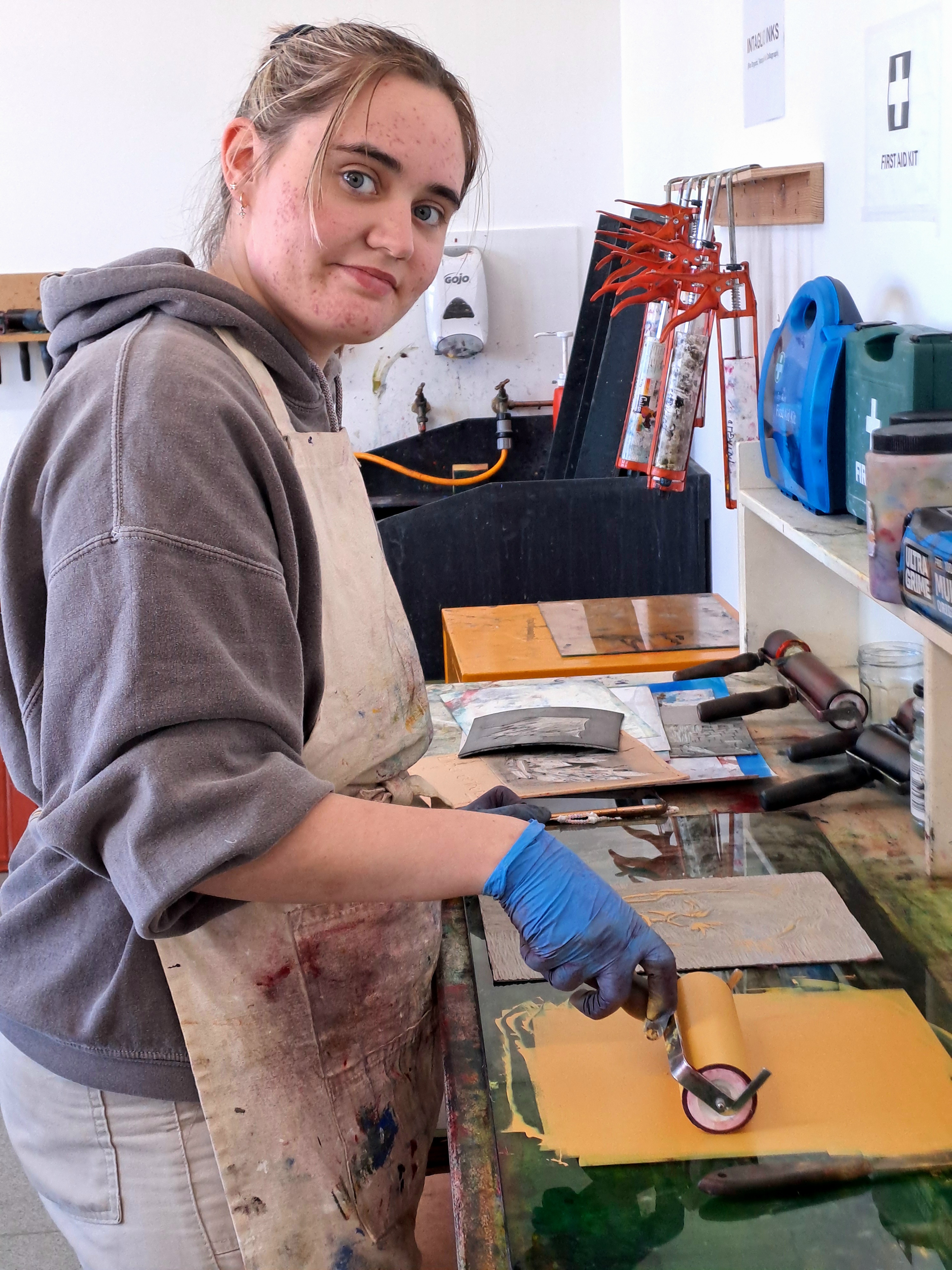 Art student using a roller to apply ink during a printmaking session at Glasgow Kelvin College